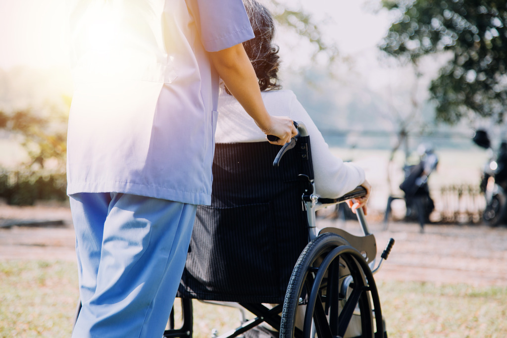 Skilled Nursing Facility Employee Pushes Wheelchair