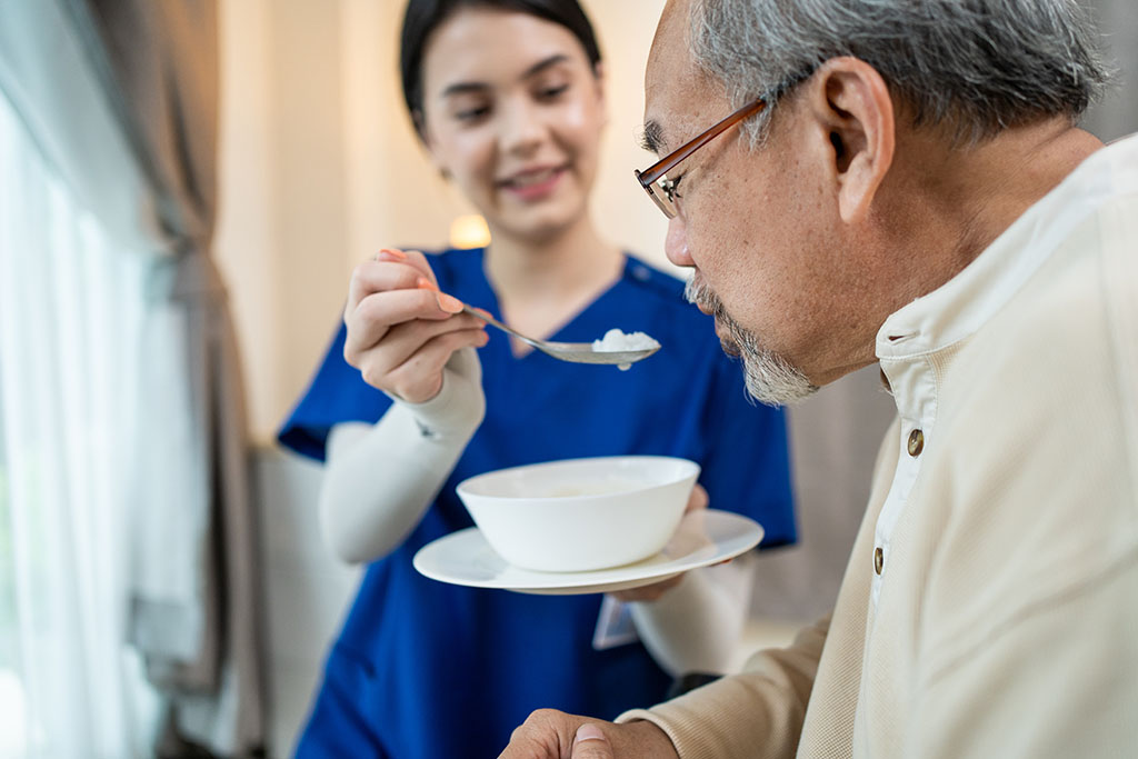 A Senior Asian Man Being Fed a Soft Food by a Young Nurse Foods for Elderly With Swallowing Difficulties