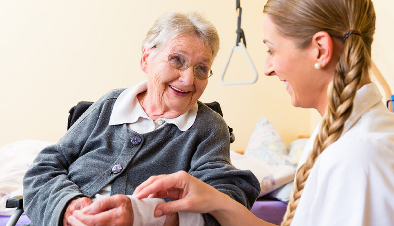 A Wound Care Specialist Bandaging a Wound on a Senior Woman’s Wrist